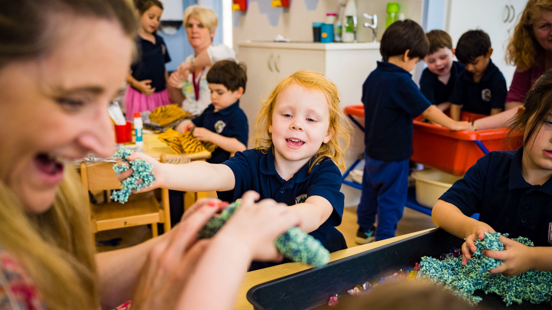 A photo of a nursery pupil playing with kinetic sand