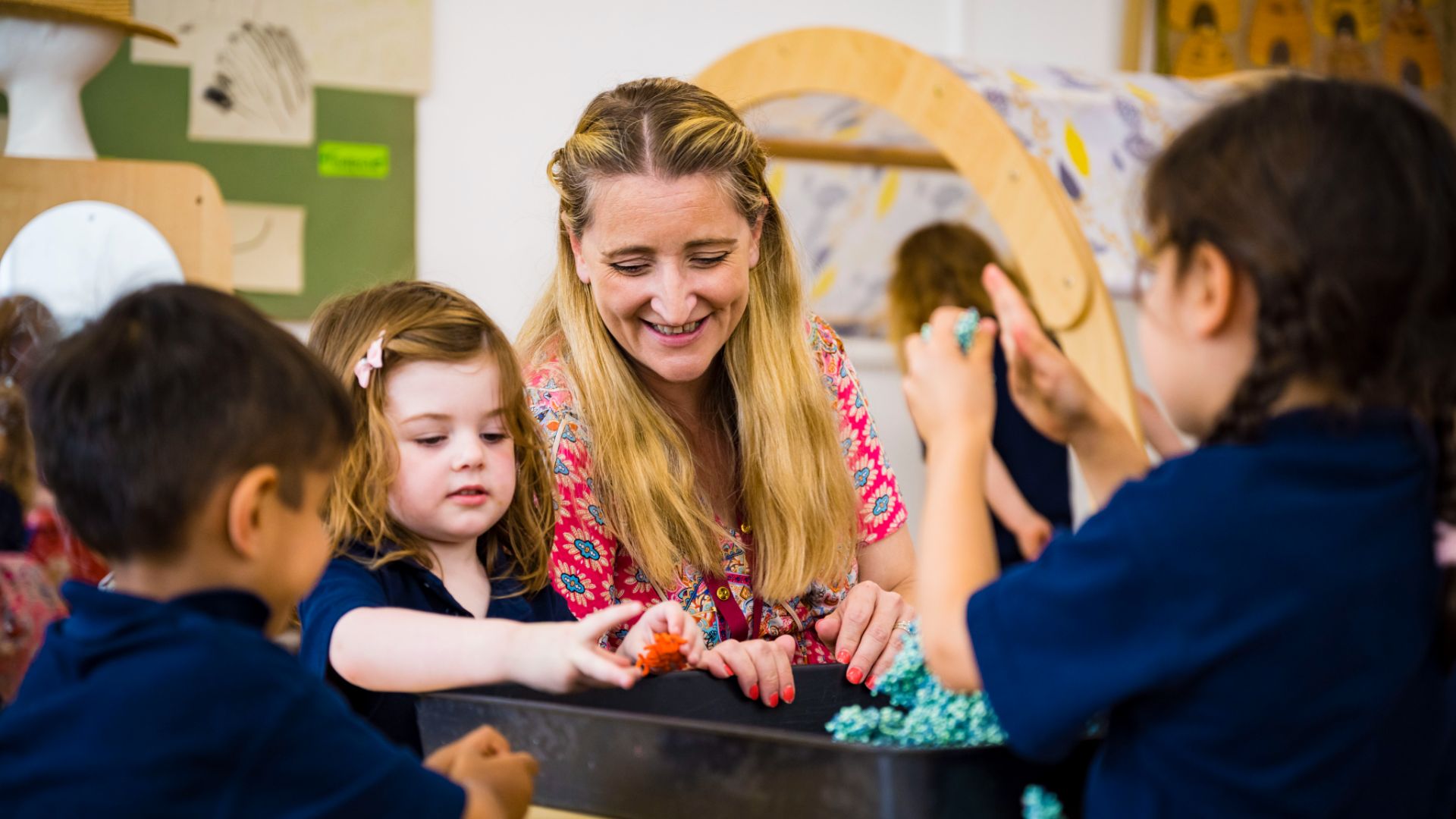 A photo of a teacher with claires court nursery pupils in class
