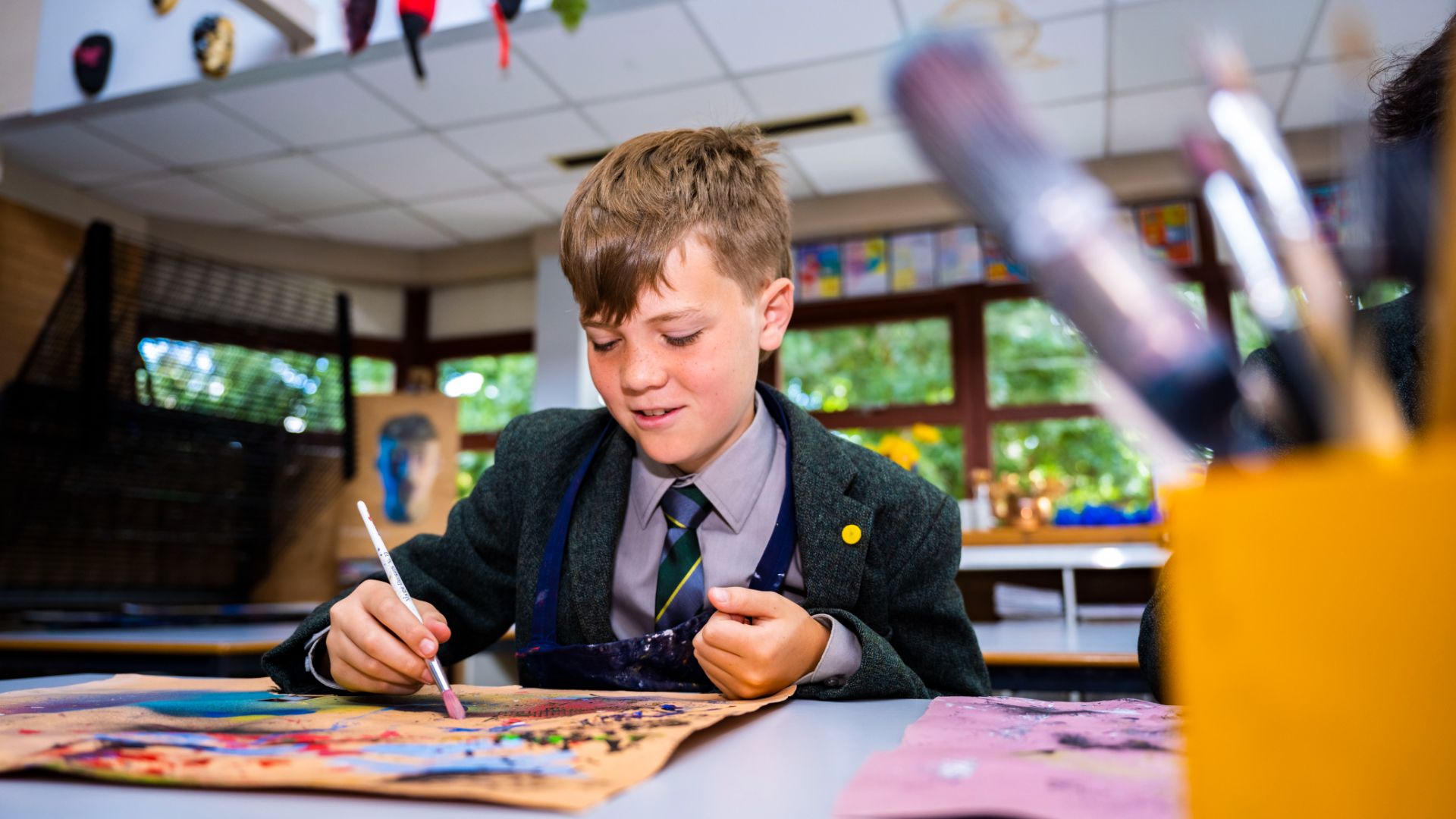 photo of a claires court senior boy pupil painting during ar class. 