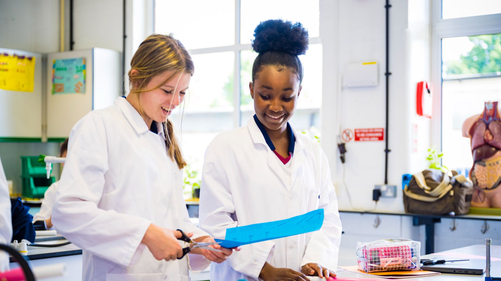A photo of claires court senior girls in the school lab during a science class