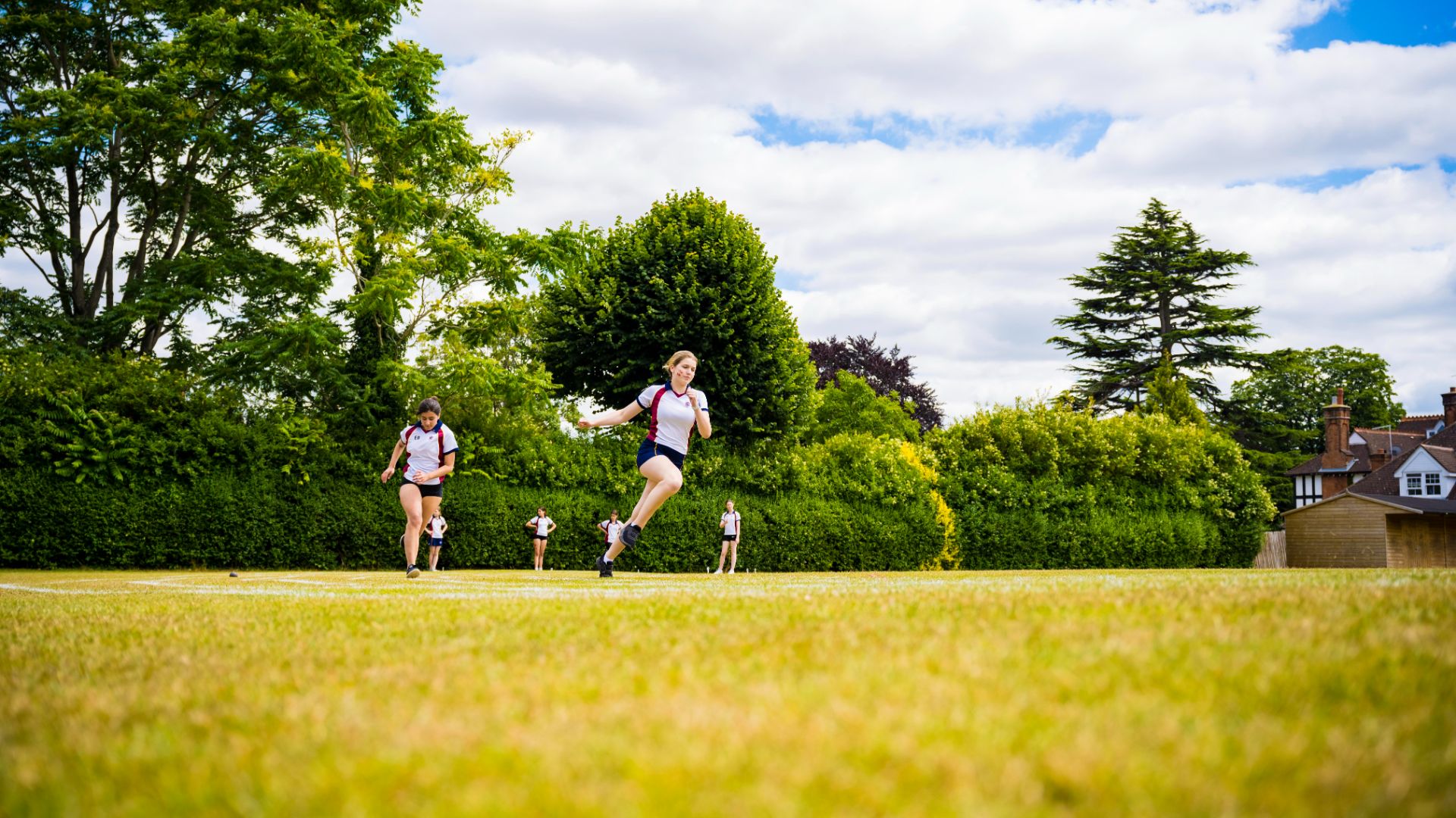 photo of girl leaping hurdles on sports day