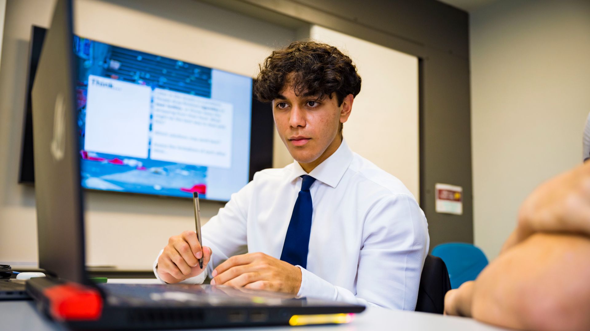 Photo of a sixth form student during a class working on his laptop